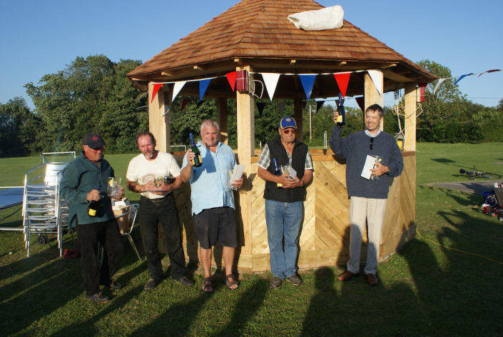 Men holding wine bottles in front of the finished rotunda